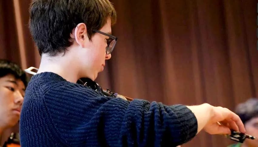 Grade 10 music - violin in orchestra rehearsal.