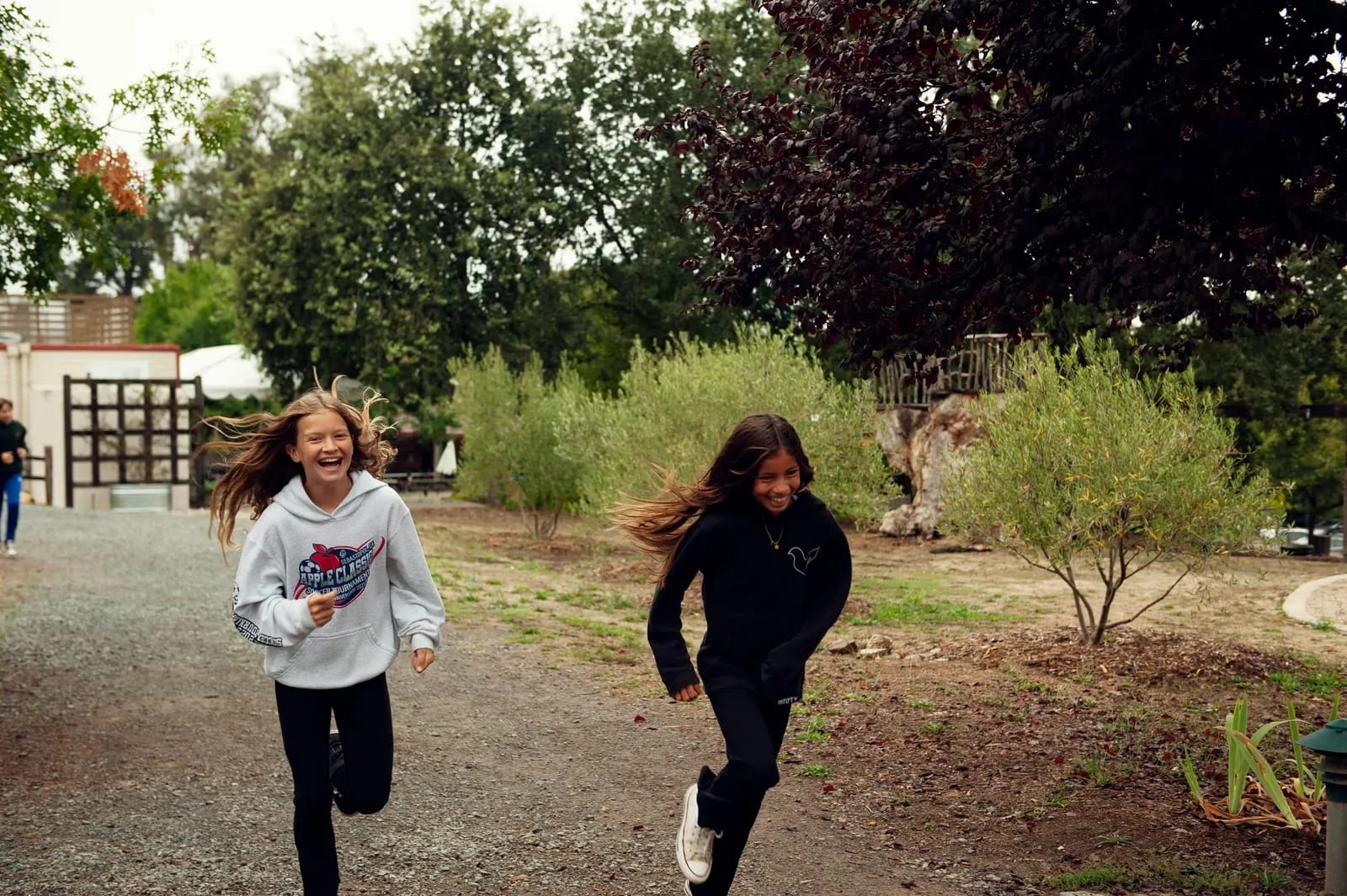 Two students racing down the gravel path.